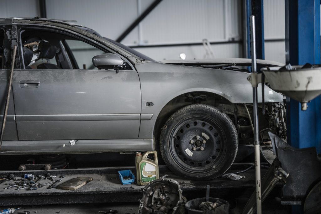 Auto op de brug in de werkplaats, met gereedschap op de vloer